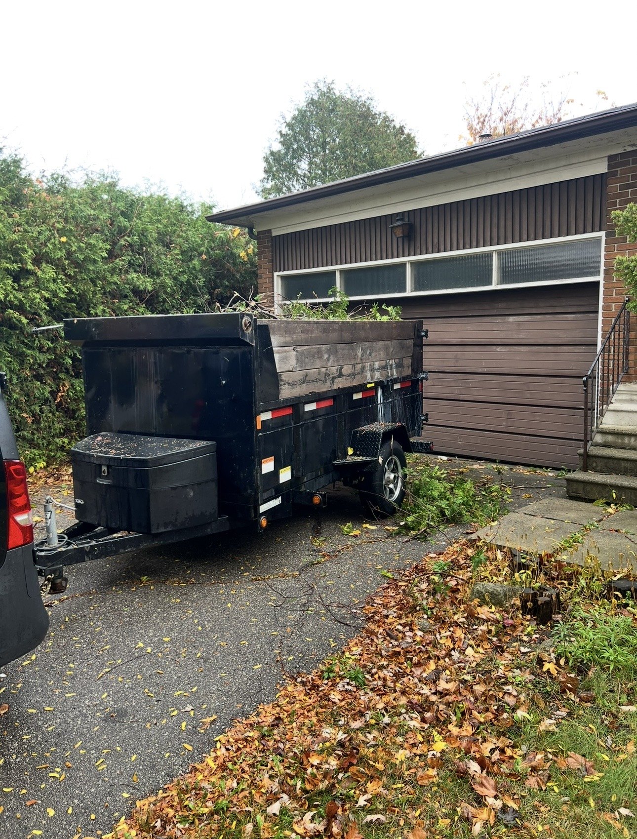 V Rentals dump trailer loaded with branches and yard waste in a Toronto driveway